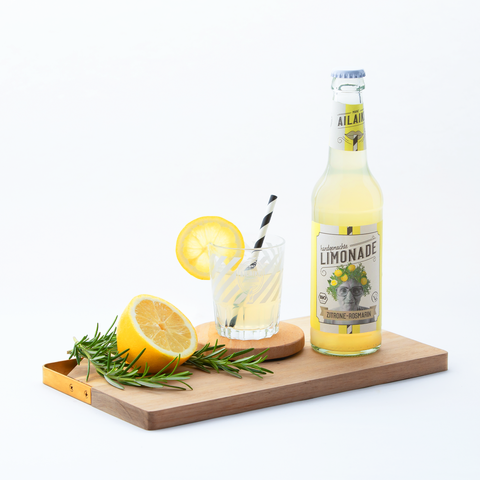 AiLaike Bio-Limonade Zitrone-Rosmarin serviert auf Holzbrett