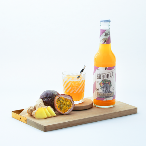 Maracuja-Ingwer-Schorle mit Flasche, Glas, Maracuja und Ingwer
